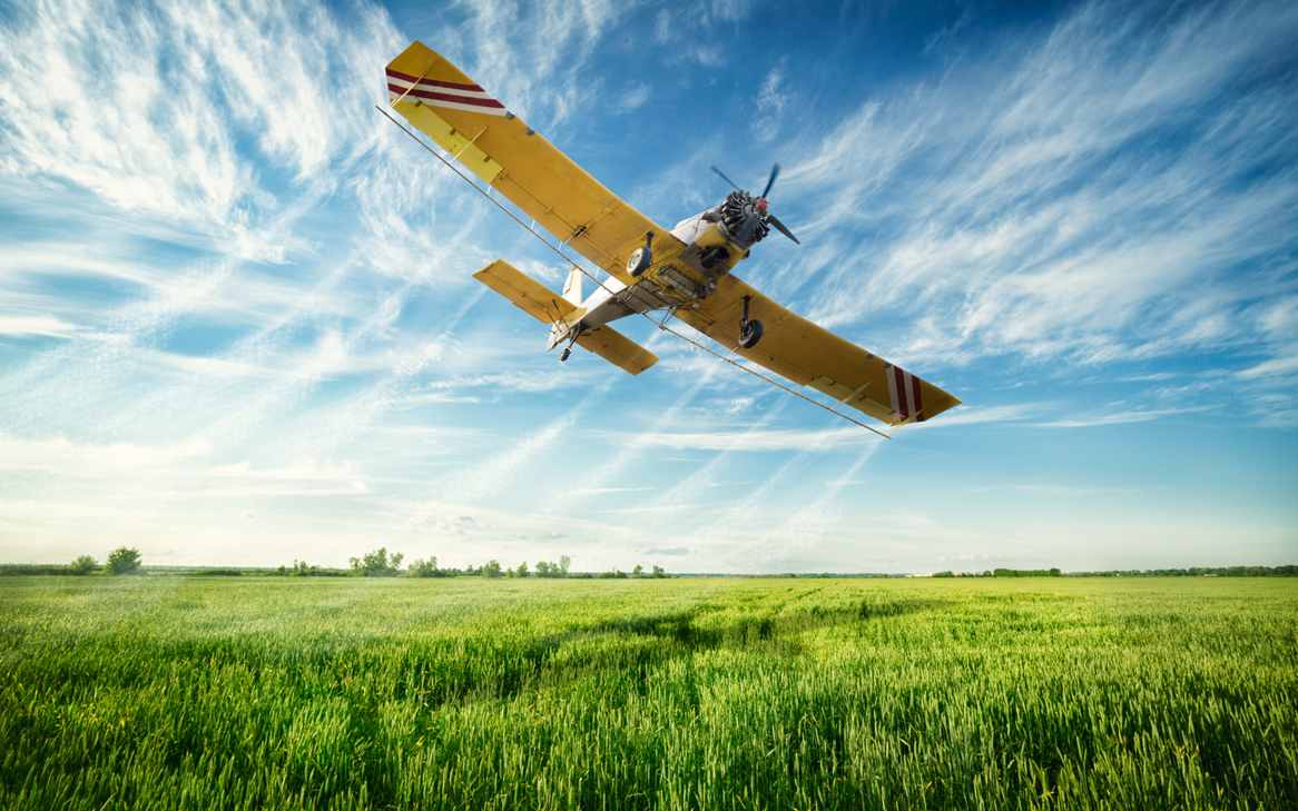 Low-flying agriculture plane spraying pesticides